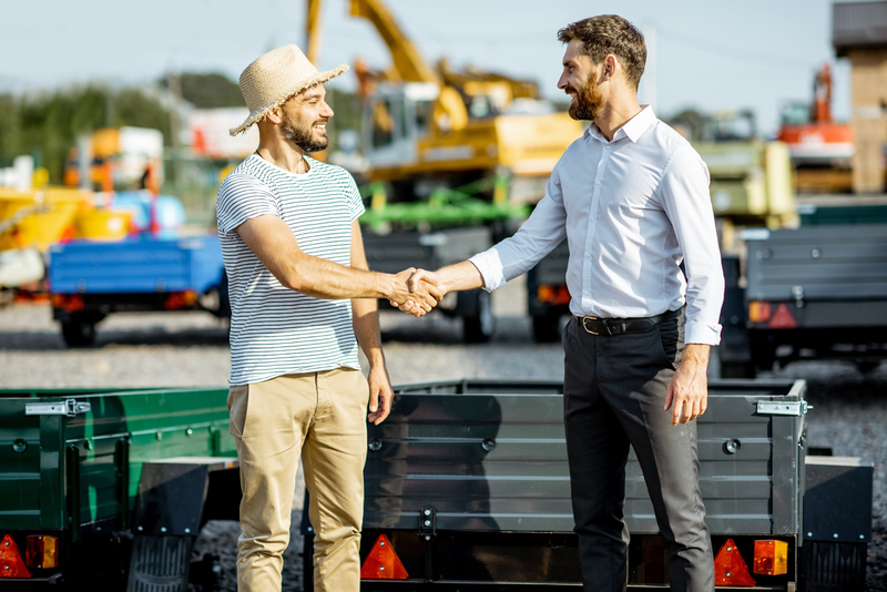 Trailer Salesman selling grey trailer to man with hat